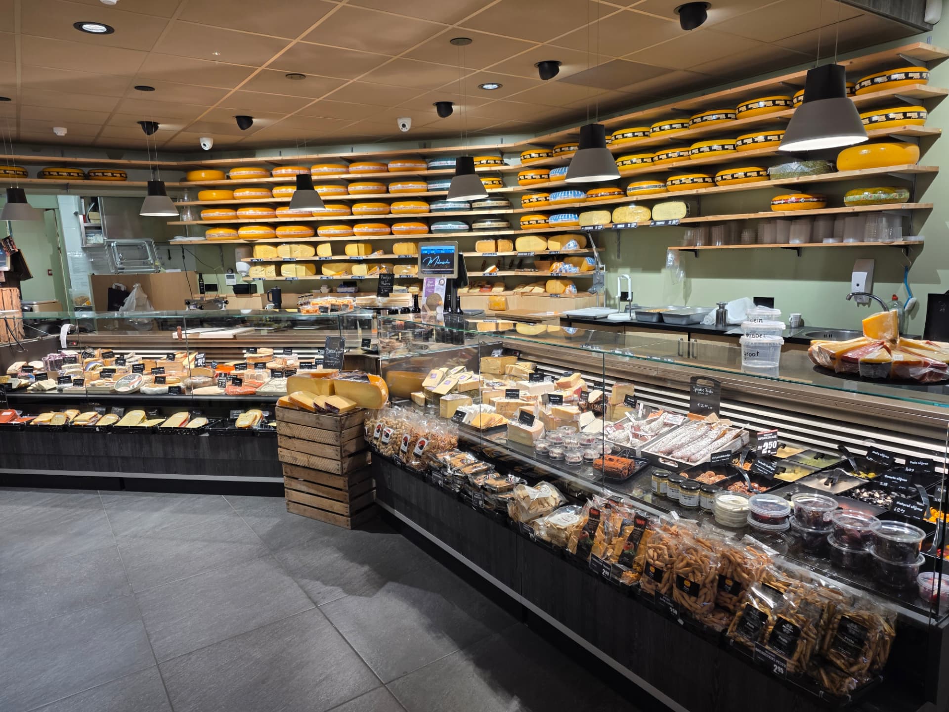 De kaastoonbank in Rosmalen met kaaswielen op de schappen, vleeswaren, olijven en zoutjes