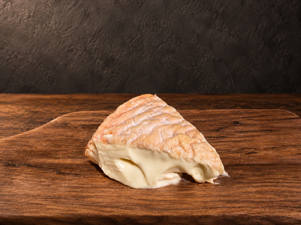 Époisses, een zachte Franse roodkorstkaas, op een warme donkere plank