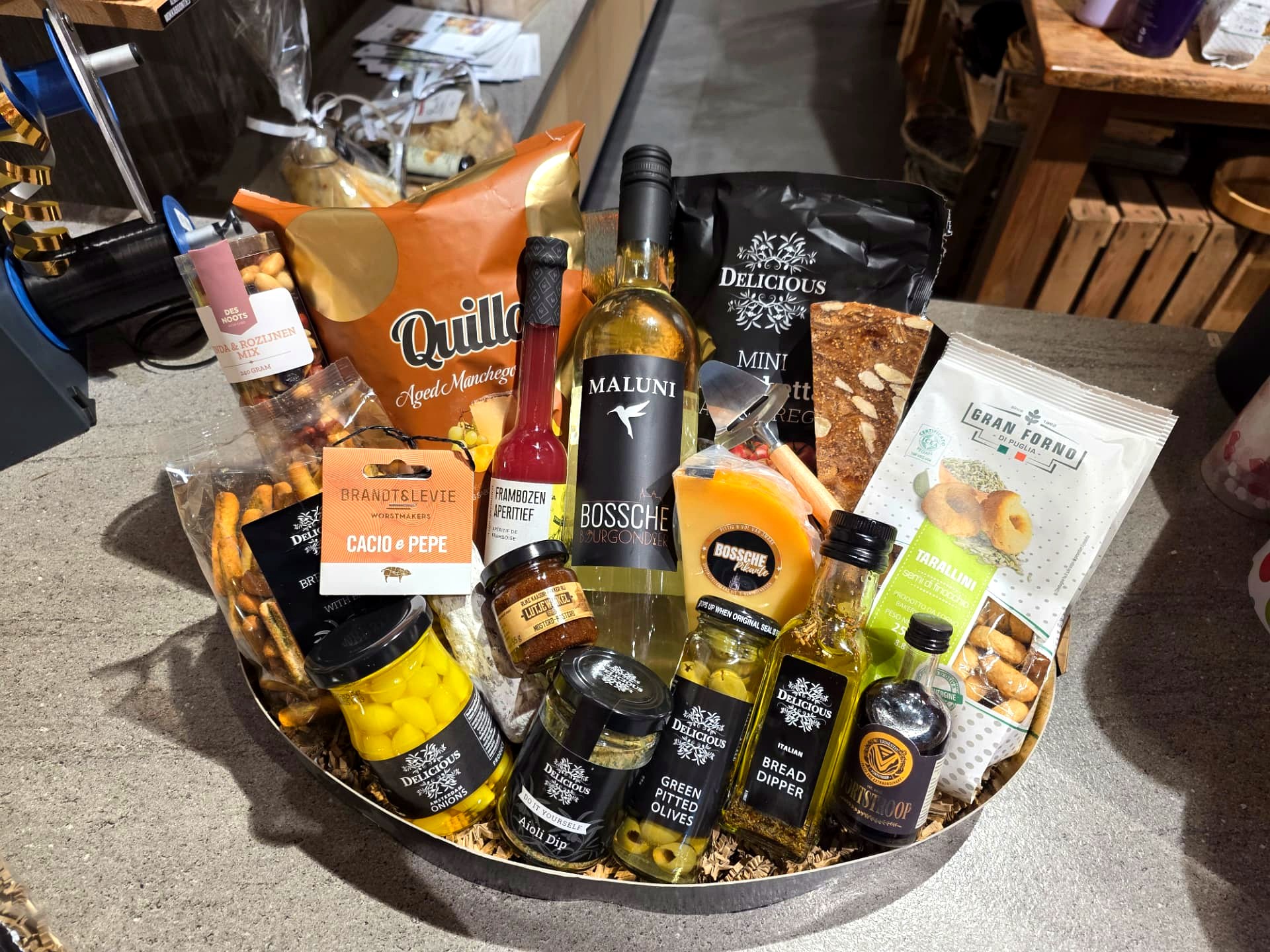 Ronde geschenkmand met Maluni Molensche Bourgondiër wijn, Bossche Pikant kaas, worst en tapas
